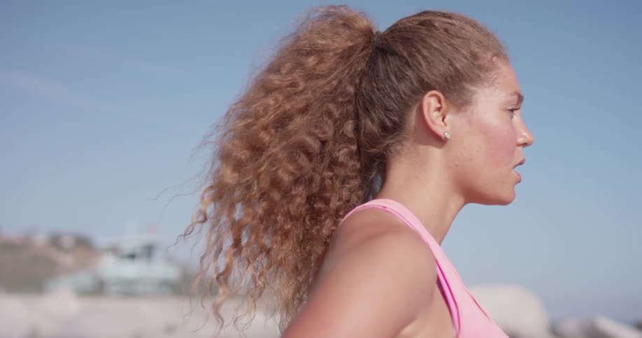 Woman is outside taking deep breaths and stretching on sunny day