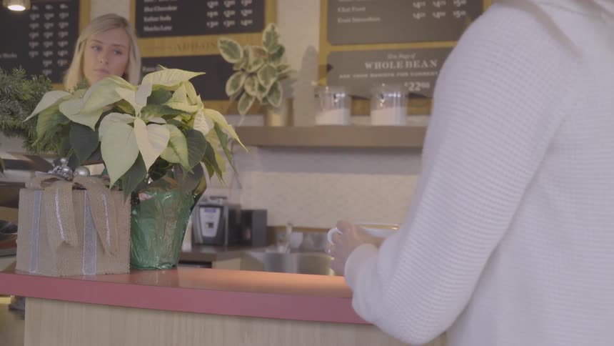 A customer carries a coffee cup away from the counter