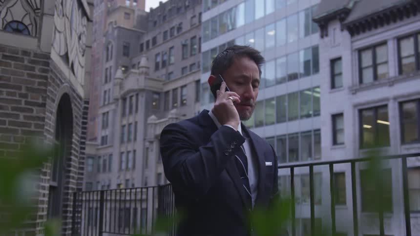 A man is talking on the phone near the building