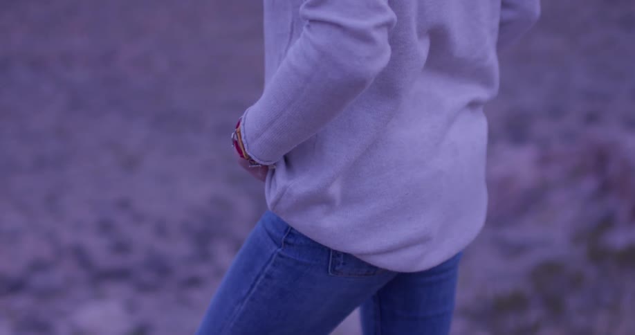 A woman stands alone in a desert