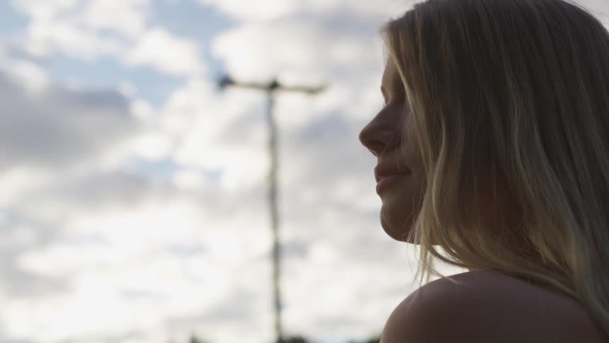 A woman looks over to her side on a cloudy day
