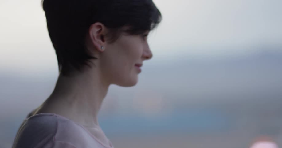 Woman leans against a balcony smiling