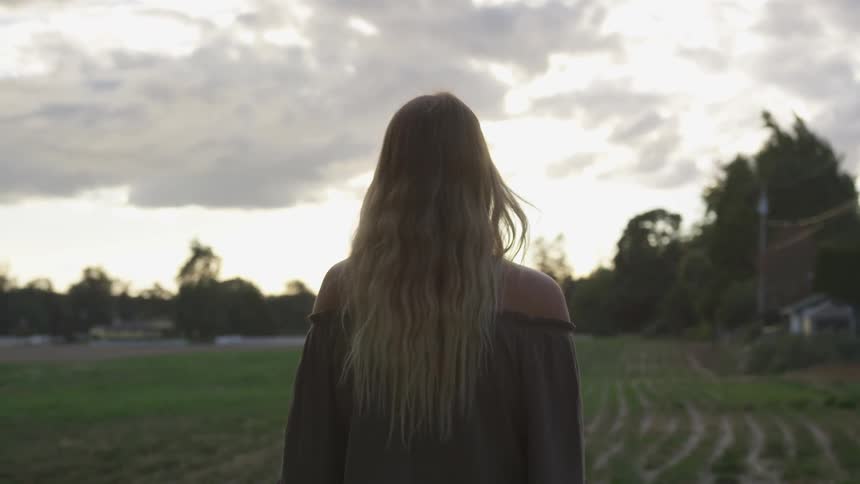 A woman slowly walks on the farm