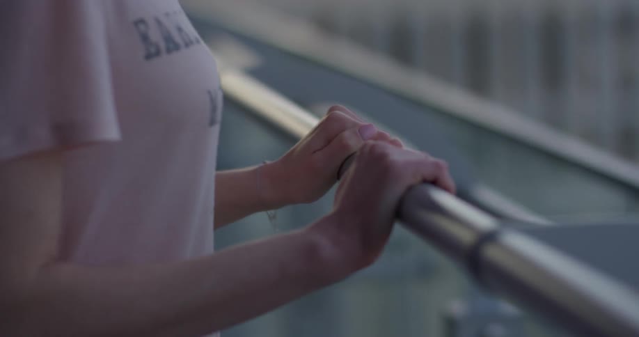A woman leans against the rail of a hotel balcony