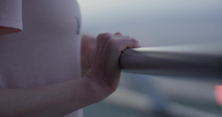 Person leans against a balcony railing