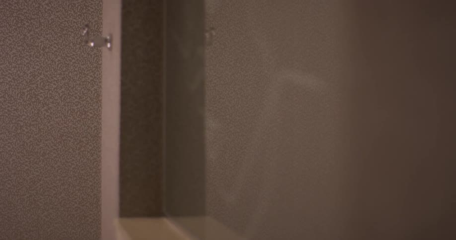 A woman exits the room wearing a towel