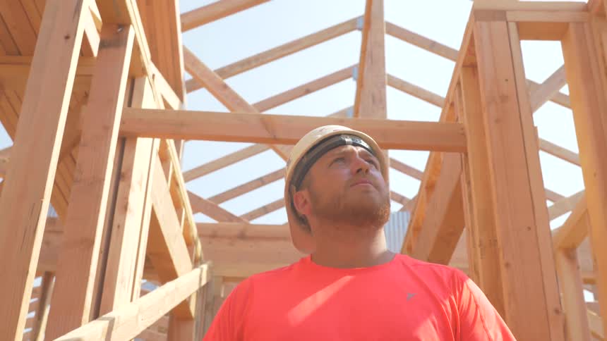 Construction worker is walking through house being built