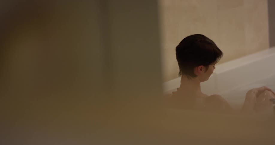 A woman washes herself while taking a bath