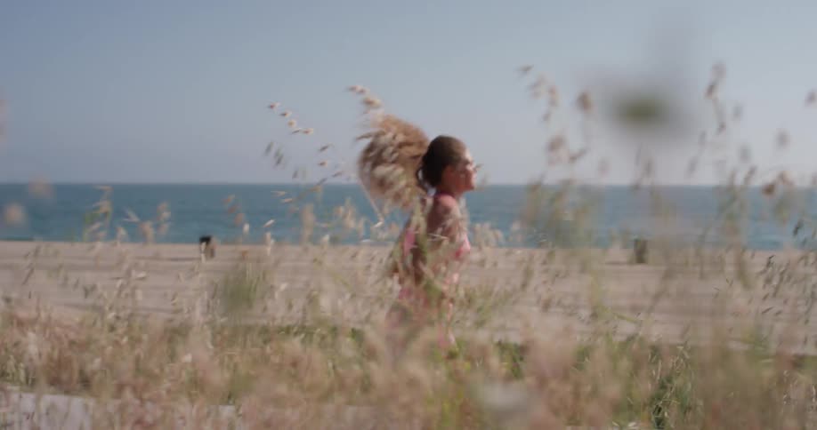 A woman jumps up and down as she warms up for a run near the beach