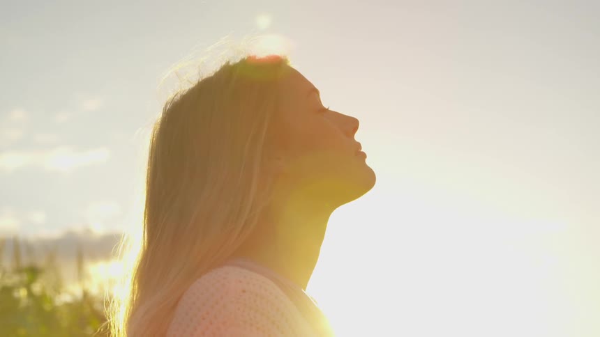 Woman turns her face up to the bright sun