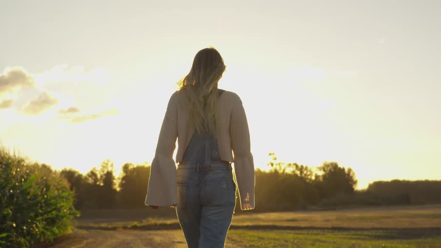 Woman walks outside in the country on a sunny day