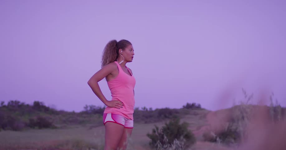 A woman puts her hands on her hips and looks around at the scenery