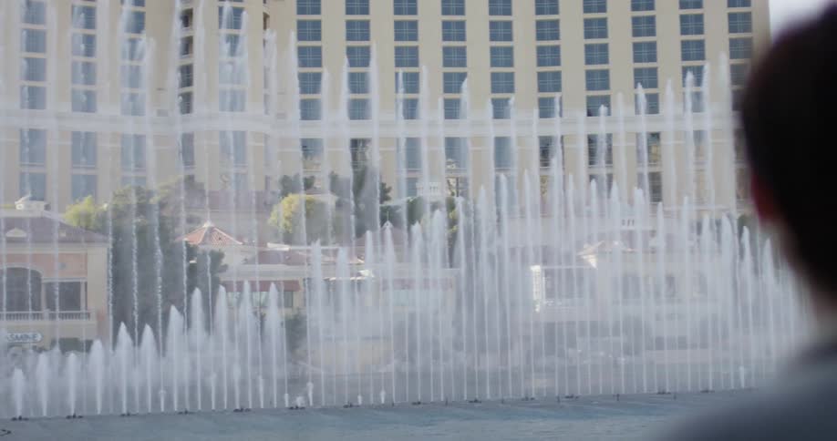Fountains spray up in front of a large hotel