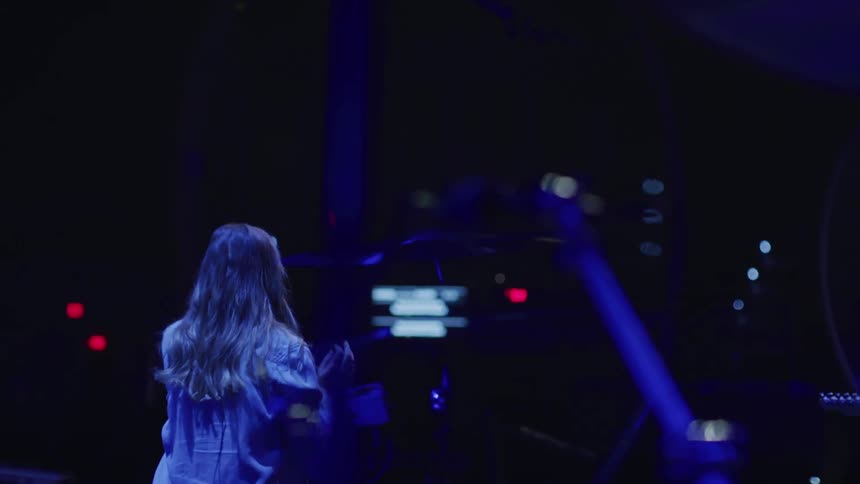 A woman is performing on the dark stage