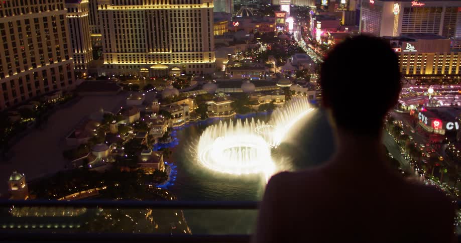 A woman looks at the fountain below from her balcony