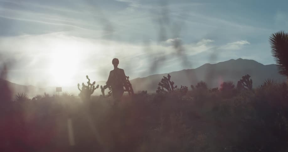 Woman is walking through desert wilderness on cloudy day