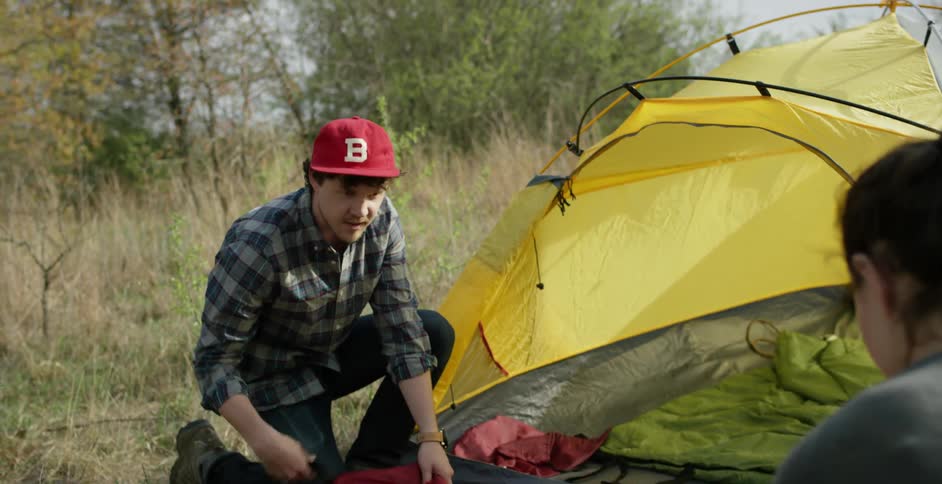 Man and woman pitching a tent in the daytime