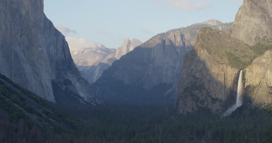 A waterfall flows over a cliff in the wilderness
