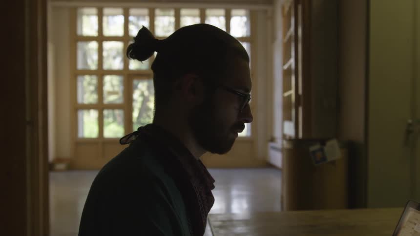 A man sits at a desk with his laptop