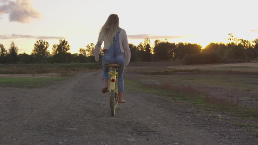Woman rides a bicycle in a field
