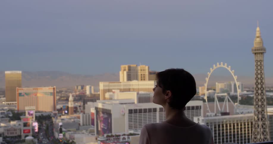 Woman stands on a balcony overlooking the city