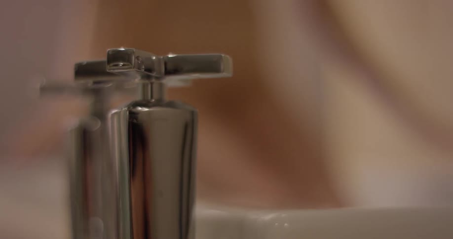 A naked woman climbs into a bathtub