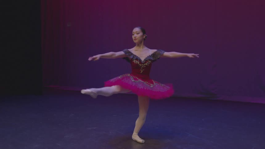A woman is dancing on the stage spinning