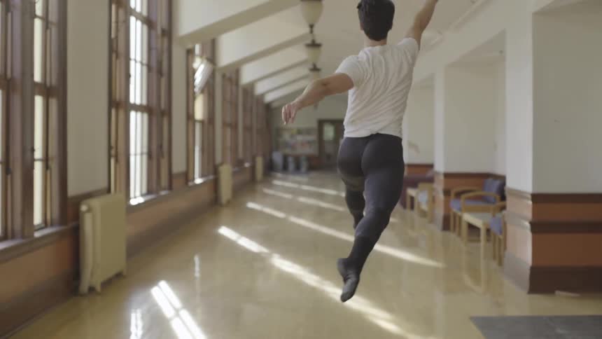 A man spins around dancing down the hall