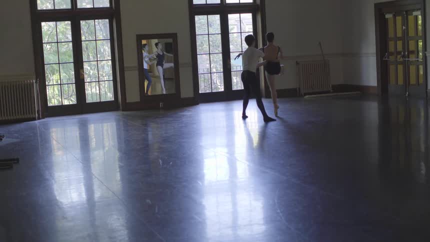 A man and woman practice dancing in the hall