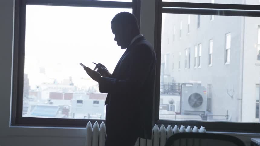 A businessman uses a tablet in an office