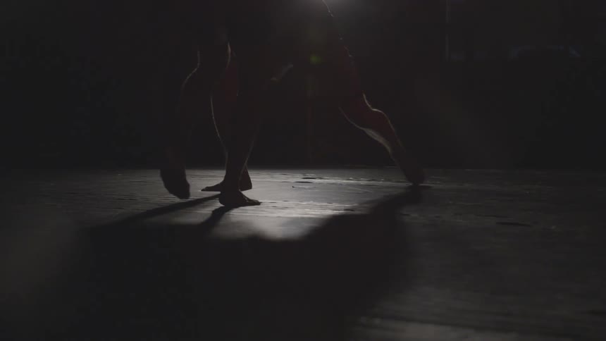 Two people spar in the dark room