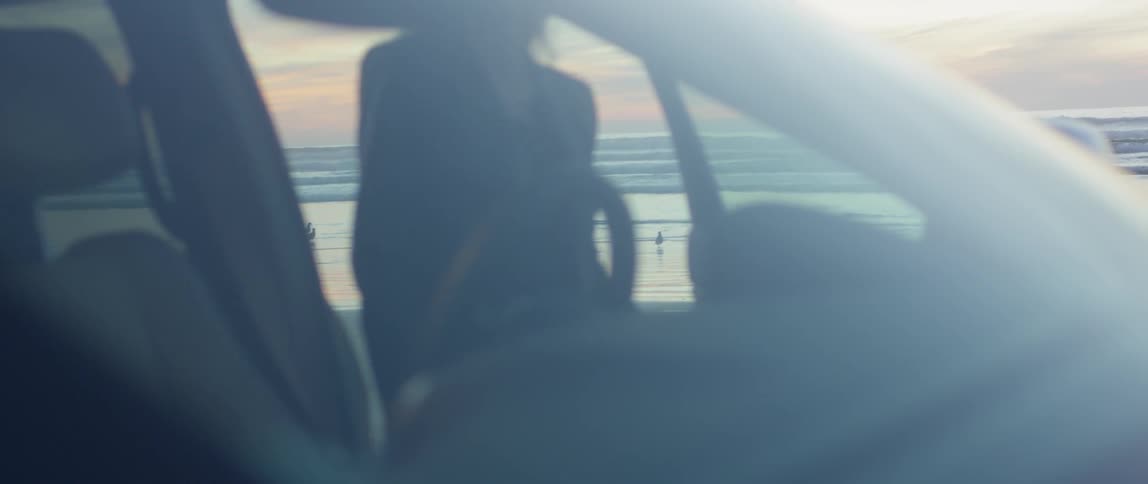 A woman gets into the car by the shore