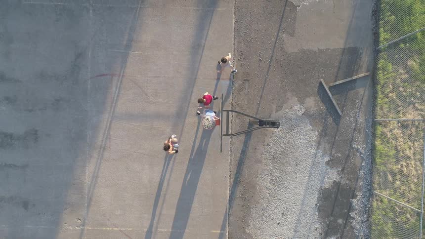 People are playing basketball on a sunny day