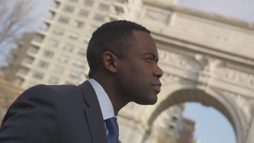A businessman stands on a city sidewalk