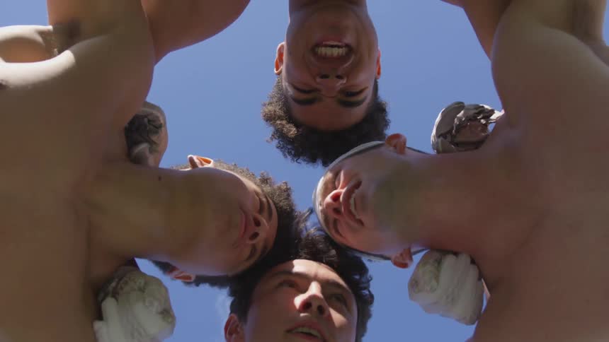 Four boys in a huddle break and walk away