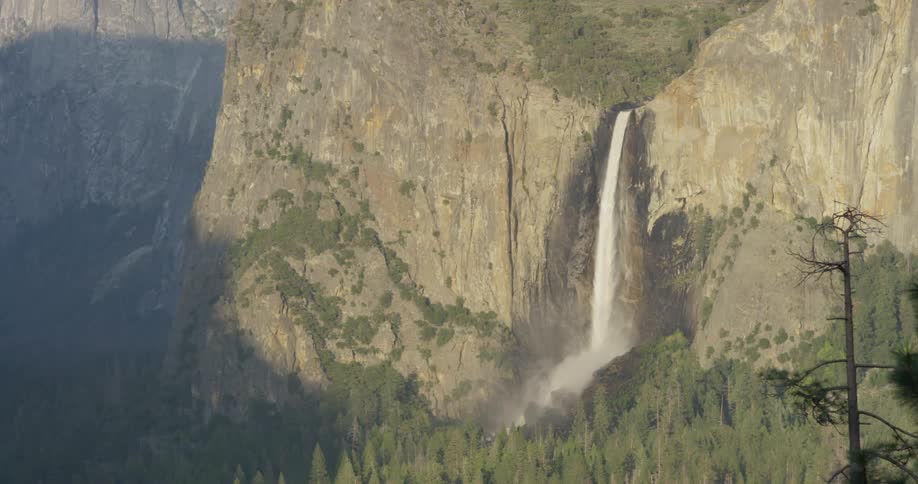 A waterfall flows over a cliff in the wilderness