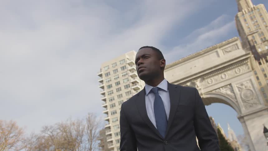 A businessman stands on a city sidewalk