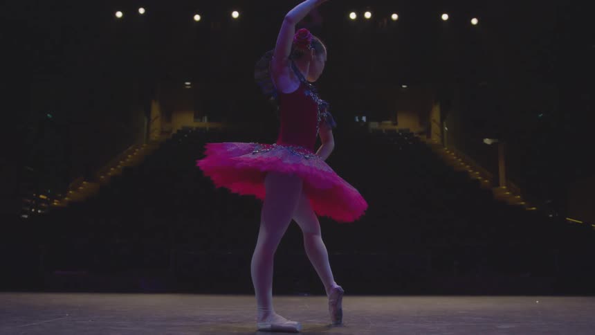 A woman dances on stage in her dress