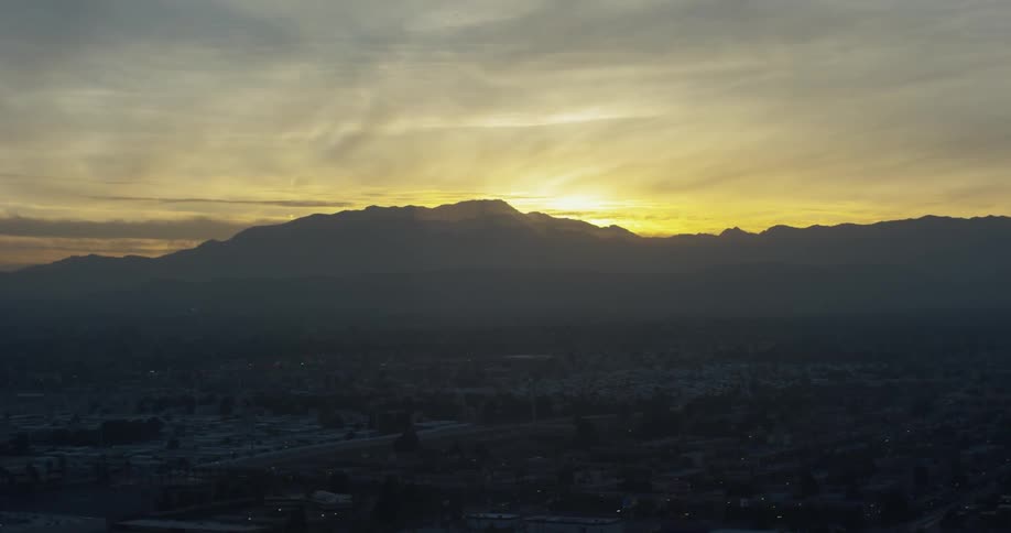 The sun is nearly set behind the mountain