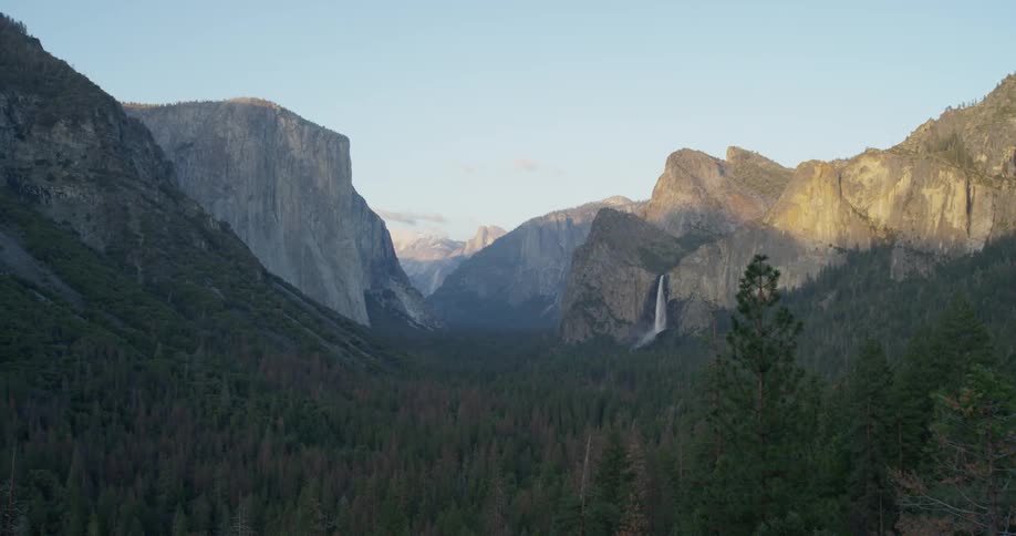 Waterfall and forest under granite rocks in yosemite