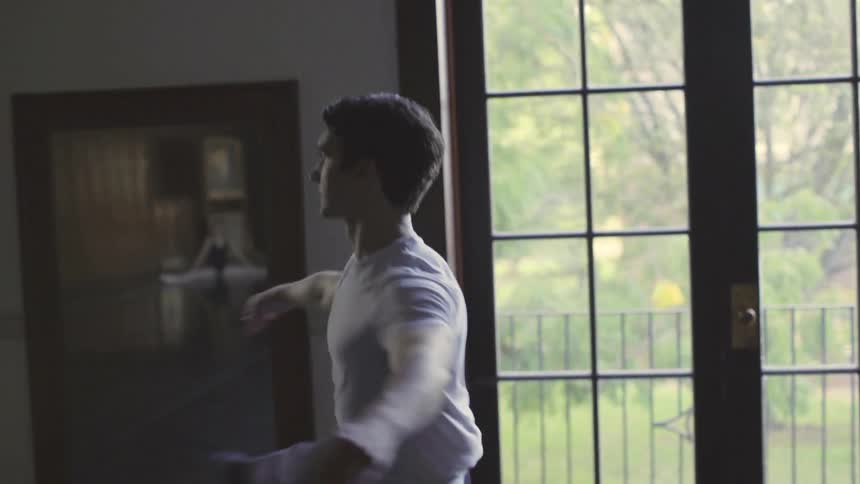 A male dancer pirouettes in a dance studio