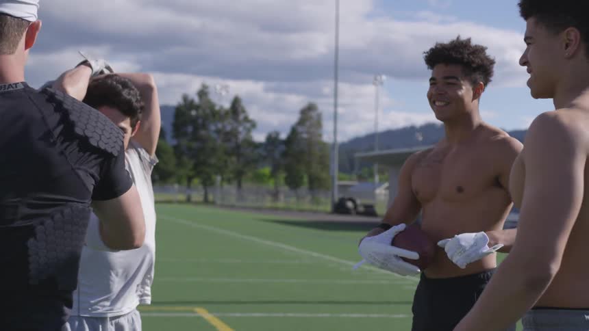 Football players warm up on an outdoor athletic field