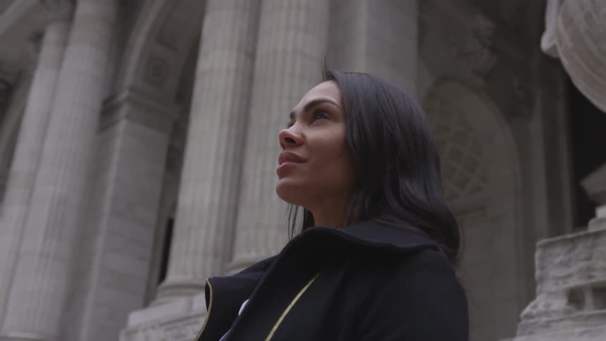 A woman walks in the city looking up