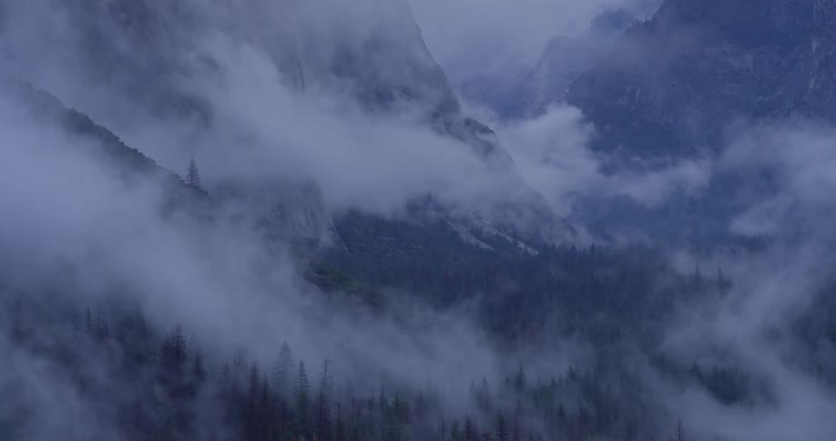Fog rolls over rocky mountains