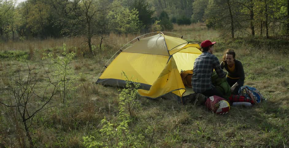 Man and woman are camping together in a forest