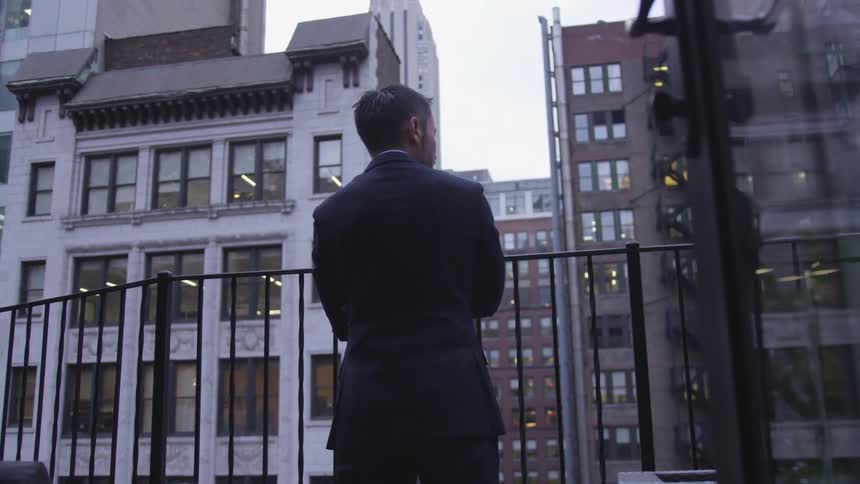 A man stands on the balcony on the city