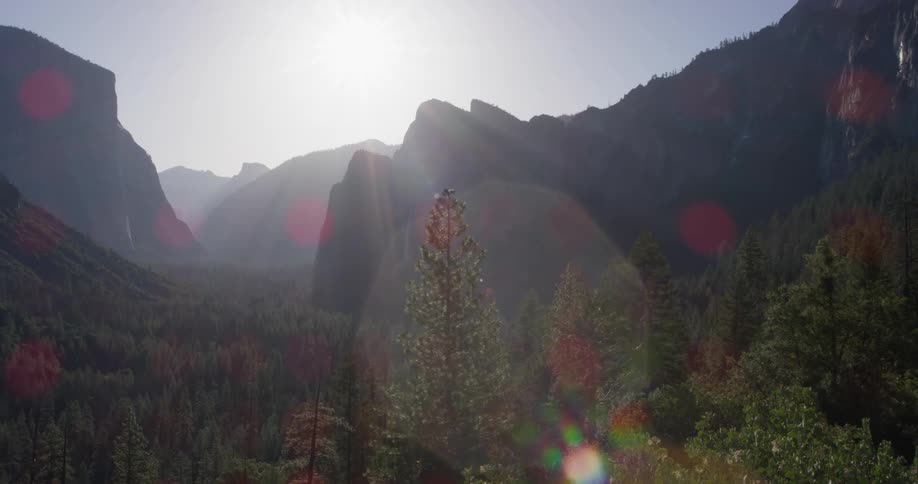 The sun shines through the fog in the mountains