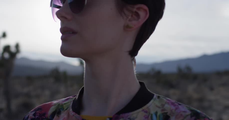 The woman brushes her hair in the desert