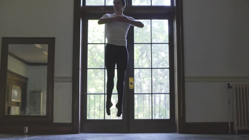Male ballet dancer jumps and spins in the air