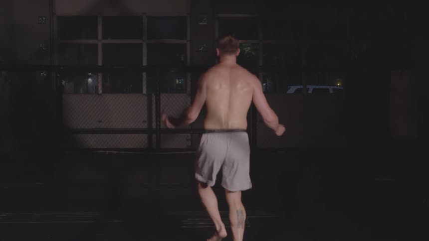 A man wearing shorts jumps rope barefoot